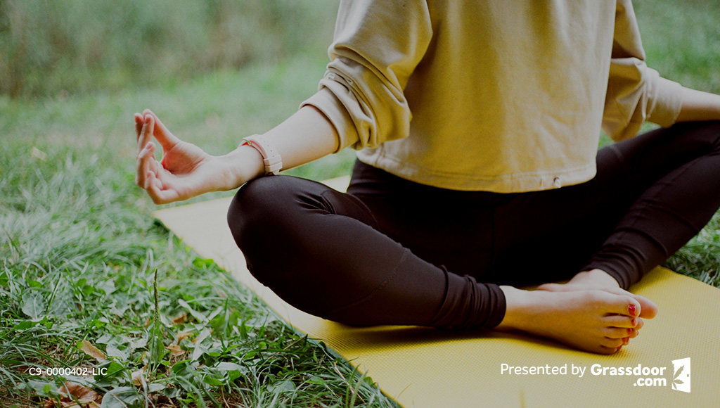 Girl meditating in the park on a yoga mat